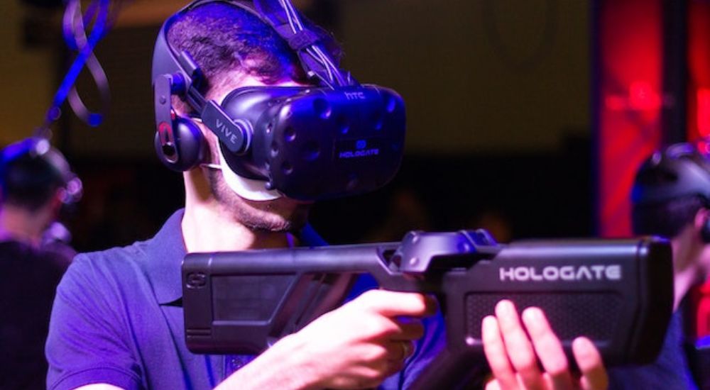 Um homem jogando com óculos e arma virtuais