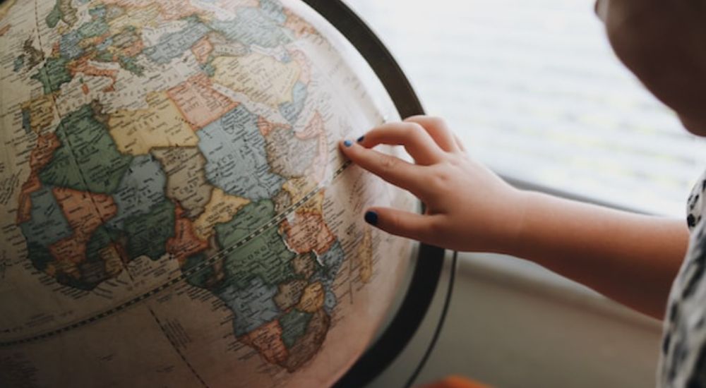 A person looking at a decorative terrestrial world globe.