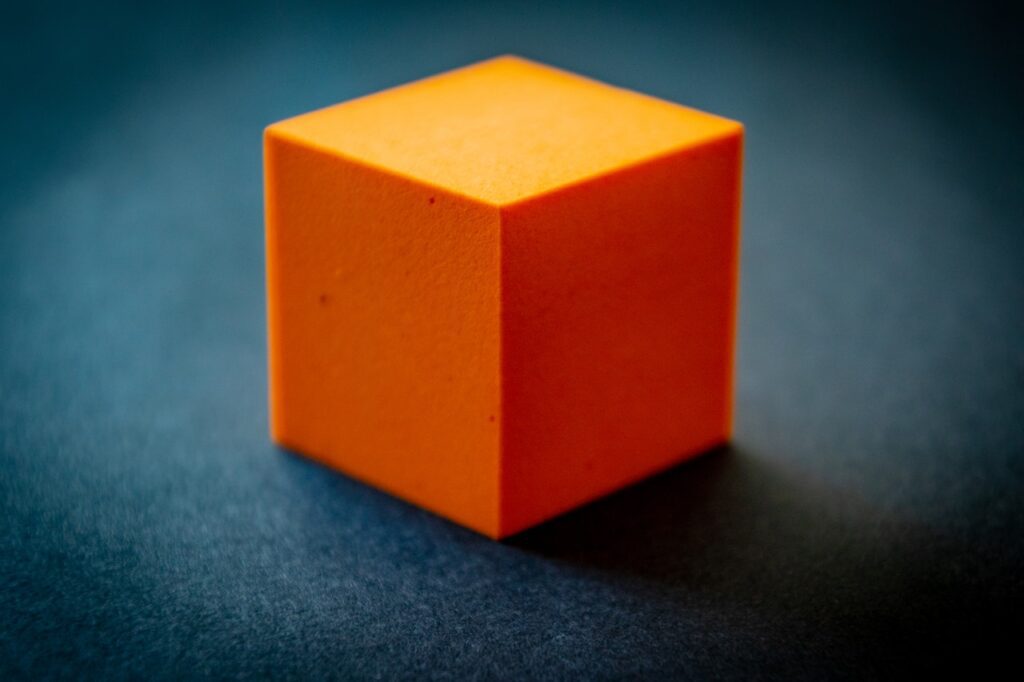 An orange cube made of foam.