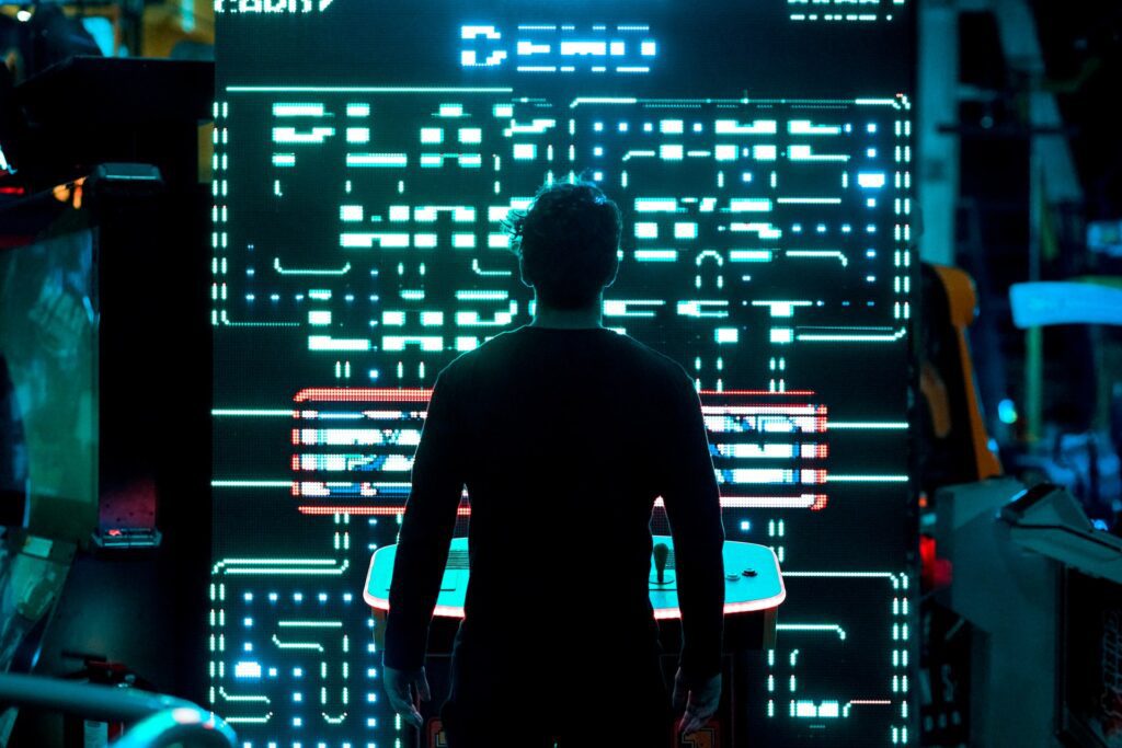 Photograph of someone playing Pac-Man on a giant screen.