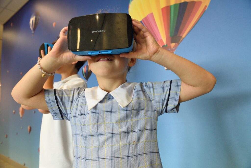 Photograph of a boy using a VR headset, a wearable gaming device.